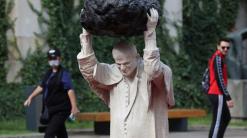 Sculpture of John Paul II with rock, red water makes waves