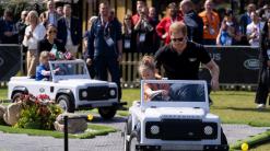 Drive time: Harry and Meghan ride in miniature Land Rovers