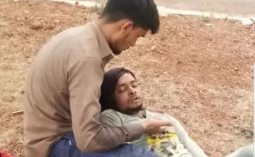 Migrant Lies On Friend's Lap On Road. Story Behind Moving Picture