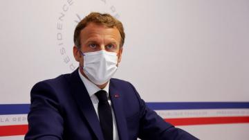 Macron warns virus is 'not behind us;' urges vaccination
