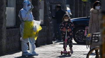 China eases some virus controls, searches pedestrians