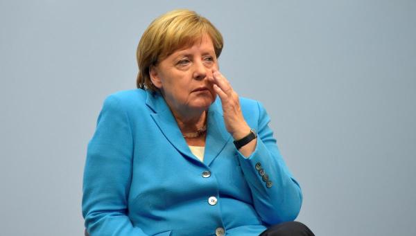 Facing far-right protest, Merkel pledges action over failed asylum seekers