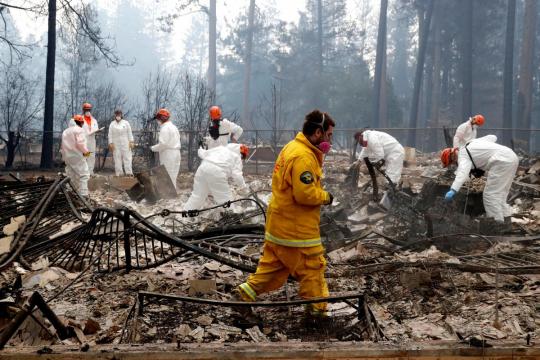 Deadly California wildfire grows as teams sift through ashes for remains