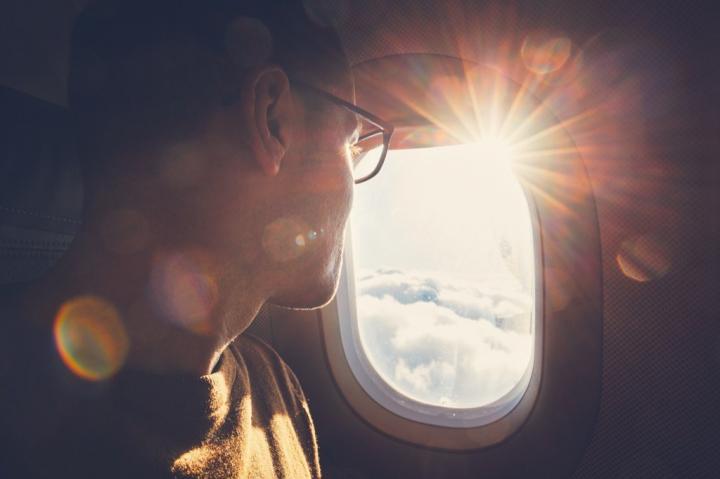 man-with-glasses-looking-out-airplane-window.jpg?resize=1024%2C682&ssl=1