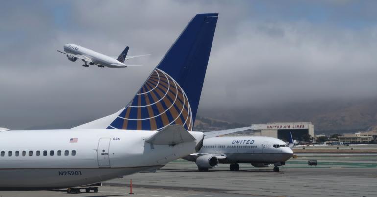 United shares surge more than 8 percent after the airline raises its outlook for the year