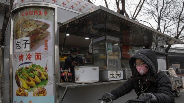 Mask-clad Chinese workers cautiously return to the office